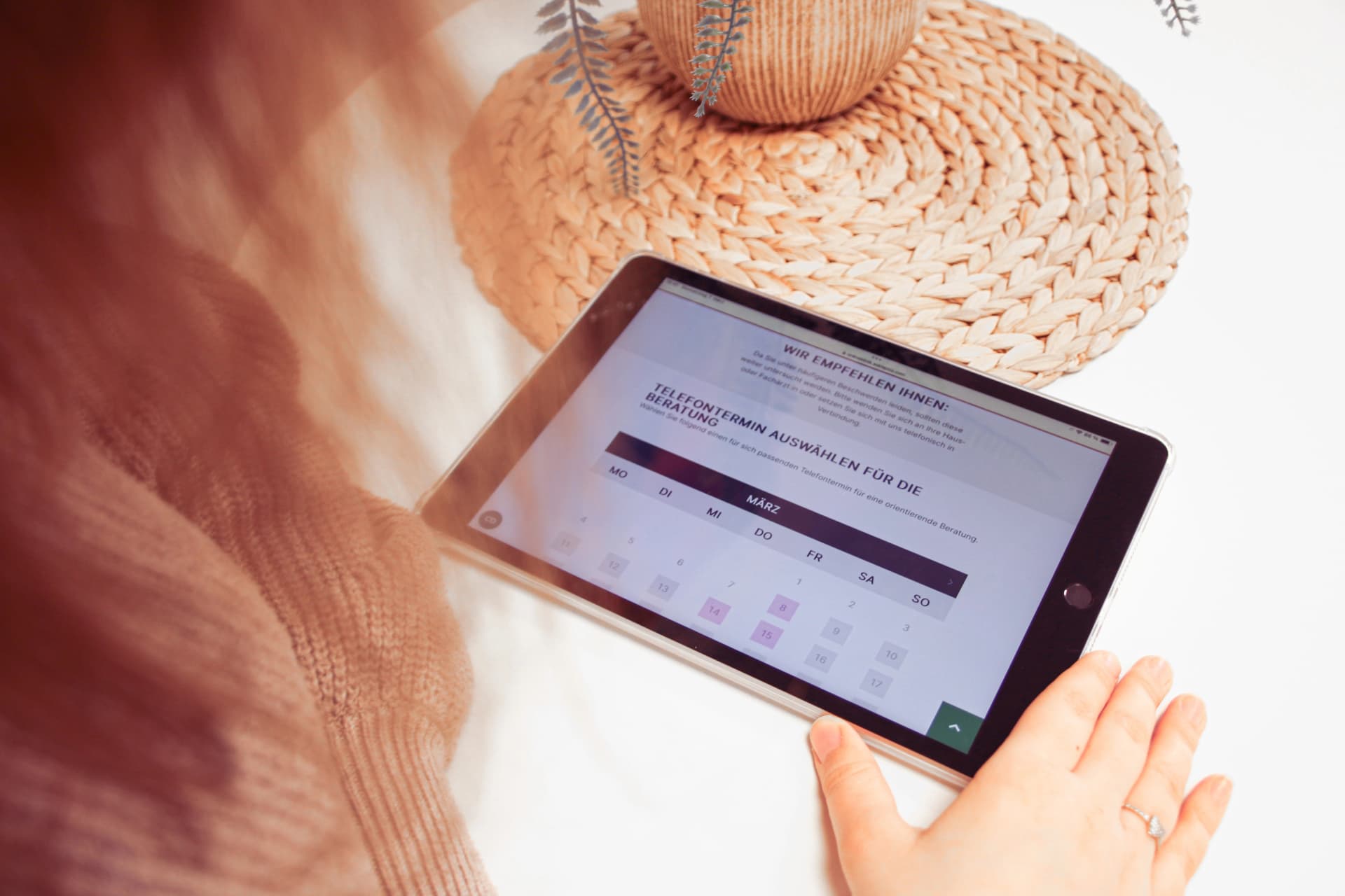 Frau schaut über ihr Tablet nach Online Beratungsterminen
